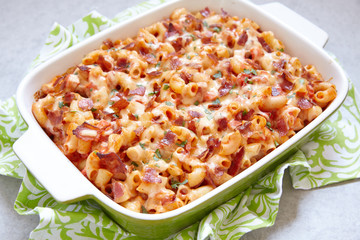 Pasta casserole with bacon, ham, cheese and tomato