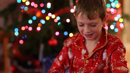Boy opening Christmas gift and get surprise - Powered by Adobe