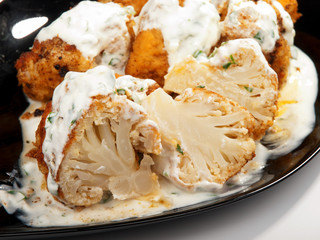 Fried Cauliflower with yogurt garlic sauce. Close up, tilted vie