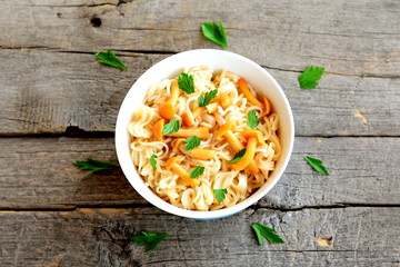 Pasta with mushrooms and herbs recipe. Pasta with marinated chanterelles mushrooms in a bowl isolated on old wooden background. Vegetarian recipe. Closeup