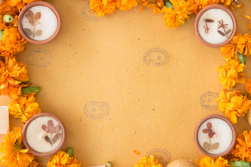 Diwali prayer celebration preparation with sweets and diyas and marigold flowers on handmade paper with Indian motifs 