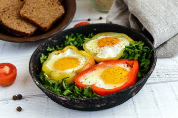 Fried egg in the ring of the bell peppers with herbs and brown bread - light diet breakfast.