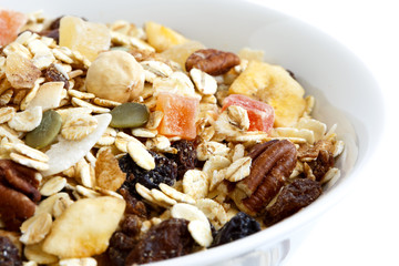 Detail of breakfast bowl of fruit and nut muesli  on white.