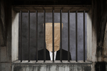 Businessman with brown paper bag on head, in jail