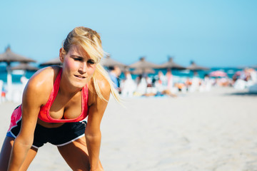 Tired sexy sportswoman on beach