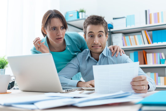 Stressed couple checking bills