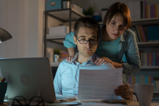 Young Couple Checking Bills At Night