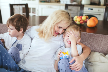 mother and sons are sitting on the couch in the kitchen