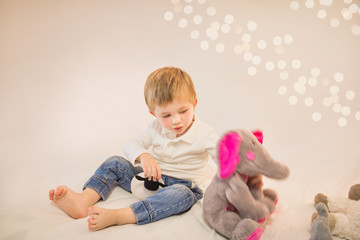 Naklejka premium Adorable little boy playing with his favourite stuffed animals