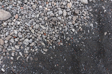 contrast between gray stones and volcanic black sand on the beac