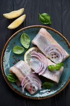 Herring fillet with onion, lemon and basil, close-up, above view
