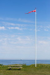 Dänische Flagge im Wind vor blauem Himmel