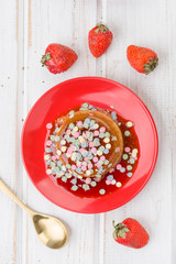 overhead shot of sweet custard garnished with confetti, on red