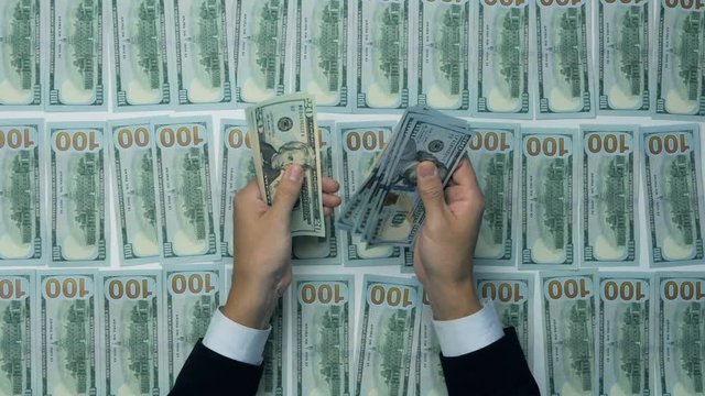 Unrecognizable man hands counting cash. Hundred new US dollar banknotes. 4K.