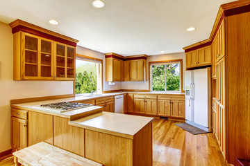 Light brown kitchen cabinets, white appliances and hardwood floor