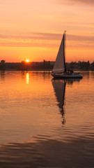 Orange sunset with a sail vertical landcsape
