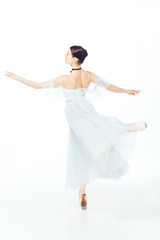 Naklejka premium Ballerina in white dress posing on pointe shoes, studio background.