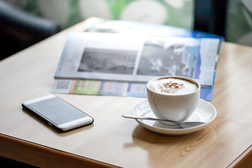 Hot coffee with smartphone in coffee shop
