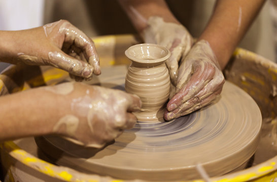 Potter shaping clay on the pottery wheel
