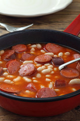salsicce e fagioli con salsa di pomodoro in padella di metallo sfondo rustico