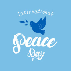 International Peace Day hand written calligraphy lettering on blue background.