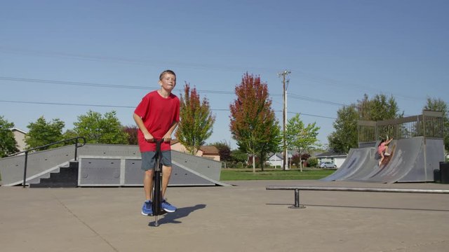 Boy jumping on Pogo stick at park