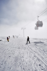 Skiers and snowboarders are on the top of the mountain in Gudauri, Geogria, near the ski lifts 