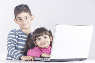 Kids having fun using a laptop computer. Education, technology and e-learning concept