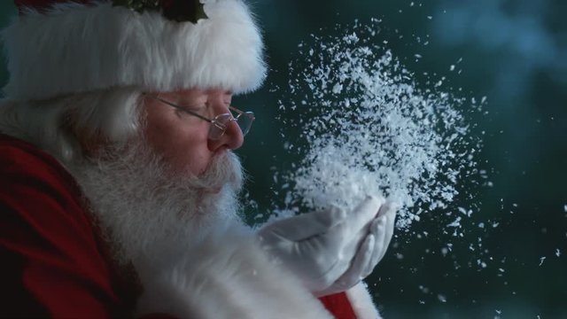 Santa Claus blowing snow from hands in slow motion