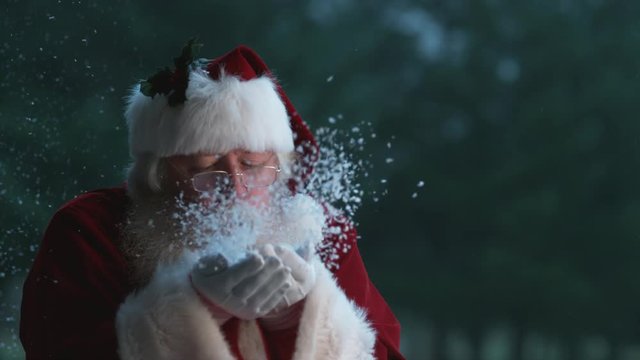 Santa Claus blowing snow from hands in slow motion