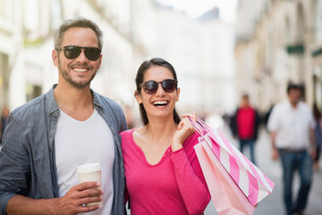 A trendy couple walking and doing shopping in the street