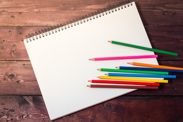  blank paper and colorful pencils on old wooden table with copy