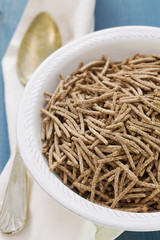 flakes in white bowl on wooden background