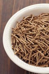 flakes in white bowl on brown wooden background