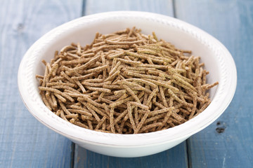 flakes in white bowl on blue wooden background