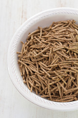 flakes in white bowl on wooden background