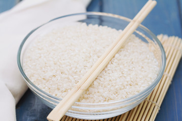 raw rice in bowl on wooden background