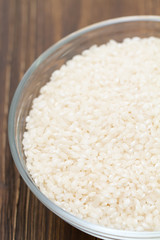 raw rice in bowl on wooden background