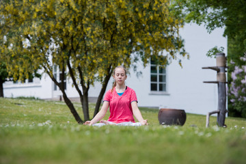 Young teenage girl doing yoga outside
