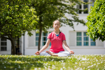 Young teenage girl doing yoga outside