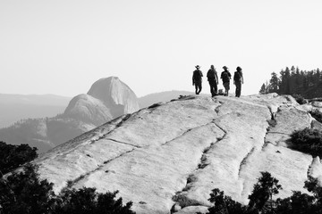 Hiker Friends climbing Yosemite's granite landscapes, With Half Dome in Distance - Black and white