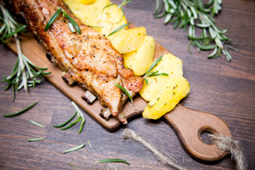 baked pork ribs with potatoes, rosemary and a glass of beer