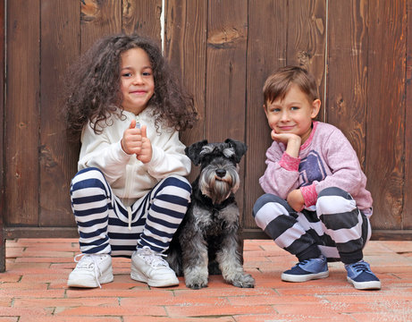 Happy smiling children with dog looking at the camera
