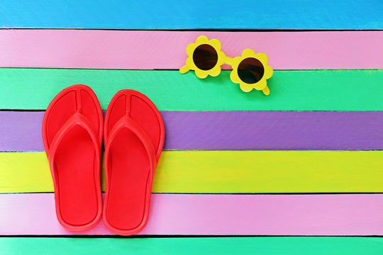  Flip flop with sunglasses on colorful wooden background