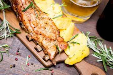 baked pork ribs with potatoes, rosemary and a glass of beer