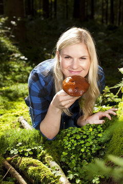Junge Frau findet essbaren Pilz im Wald
