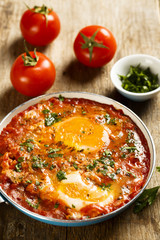 Fried eggs with tomatoes, spices and herbs