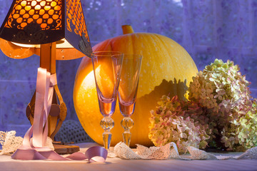 Pumpkin, glass cups, hydrangea, fonr and lamp warm light. Romant