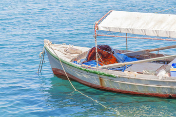 Fototapeta na wymiar Old wooden fishing red boat tied on dock