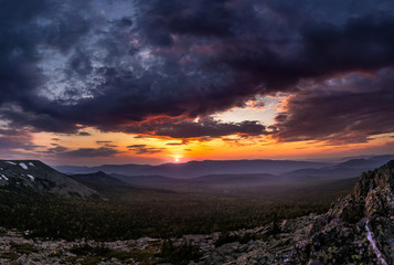 mountain valley at sunset with stones on the hillside